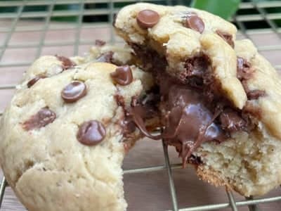 Galleta de chips de chocolate partida por la mitad con el centro de chocolate derretido